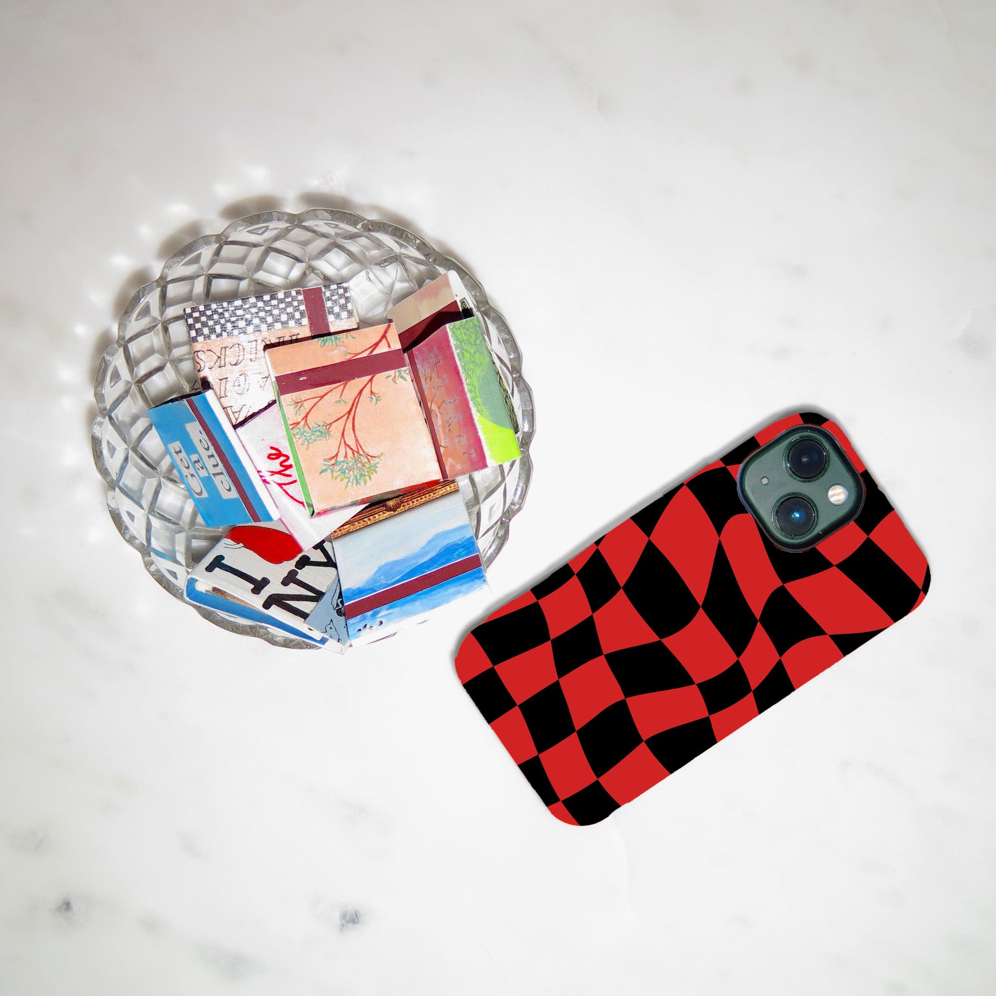 Phone case with red and black checkered pattern on a light gray surface